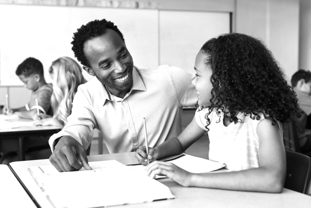 Male elementary school teacher and girl in class, close up