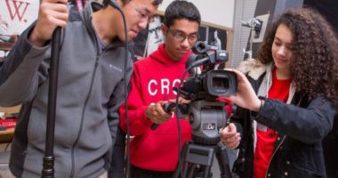 Group of high school students working with cameras