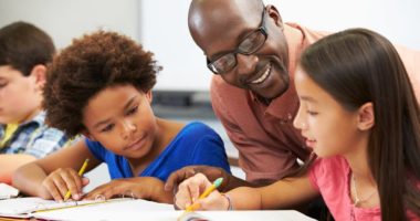 Black Teacher helping students in the classroom