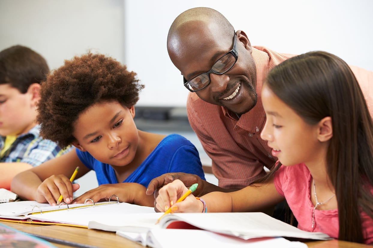 Black Teacher helping students in the classroom