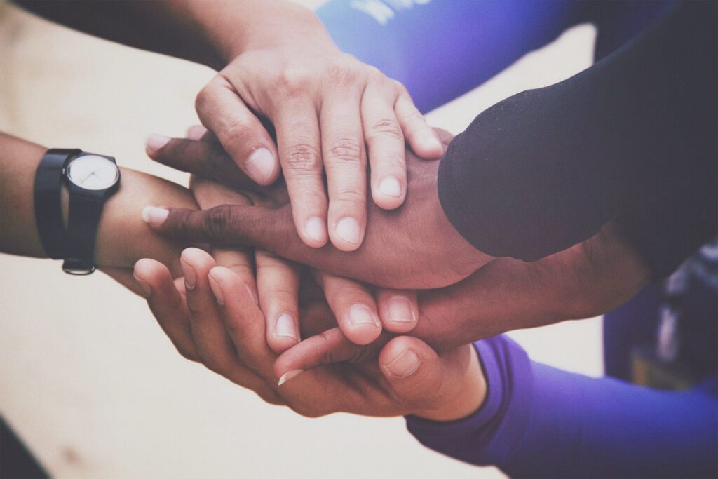 A diverse group of people joins hands