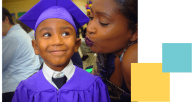 African American mother blowing a kiss at son at his kindergarten graduation