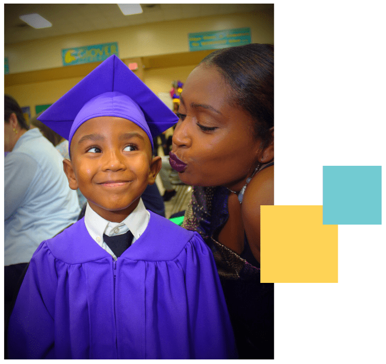 African American mother blowing a kiss at son at his kindergarten graduation