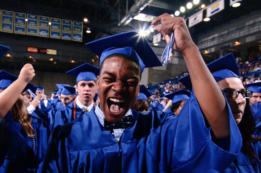 Graduation candidate celebrating while moving his tassel