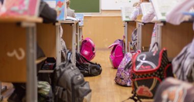 Backpacks lying next to desks in a classroom