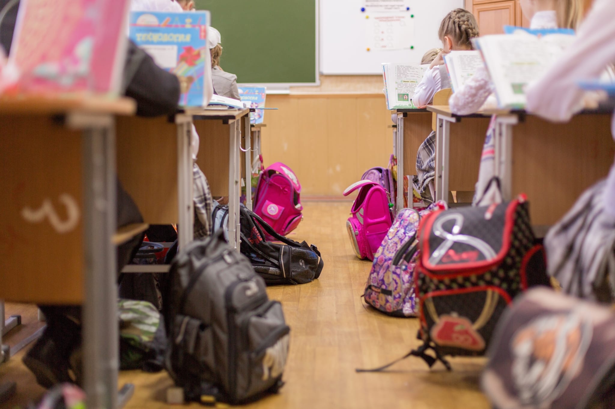 Backpacks lying next to desks in a classroom