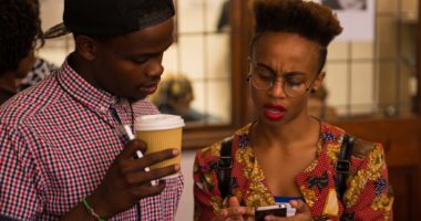 Black male and female looking at cellphone