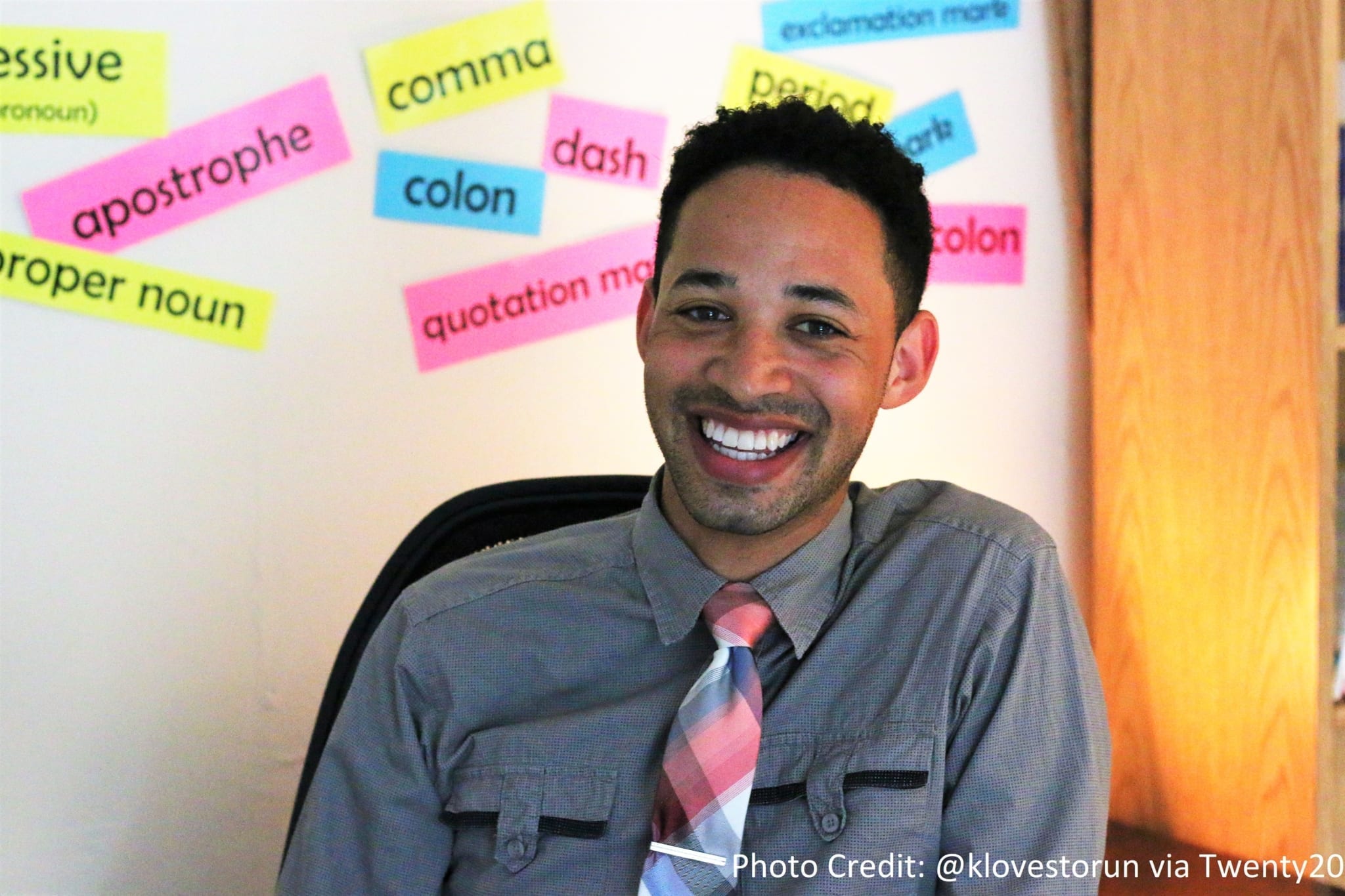 Male teacher in front of types of punctuation taped to wall