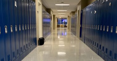 Empty school hallway with blue lockers
