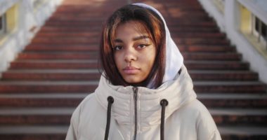 Black girl wearing hoodie, looking sad