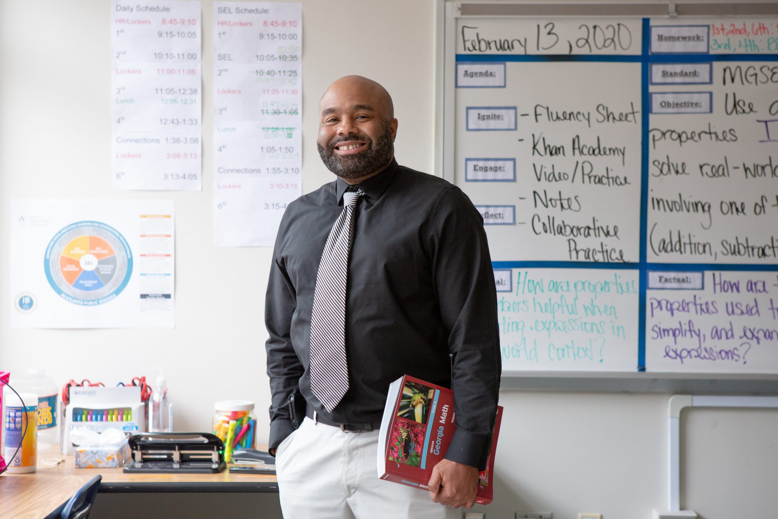 Male sixth-grade math teacher with textbook