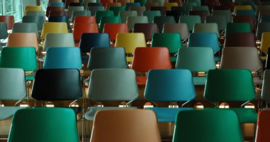 A group of different colored chairs in a classroom.
