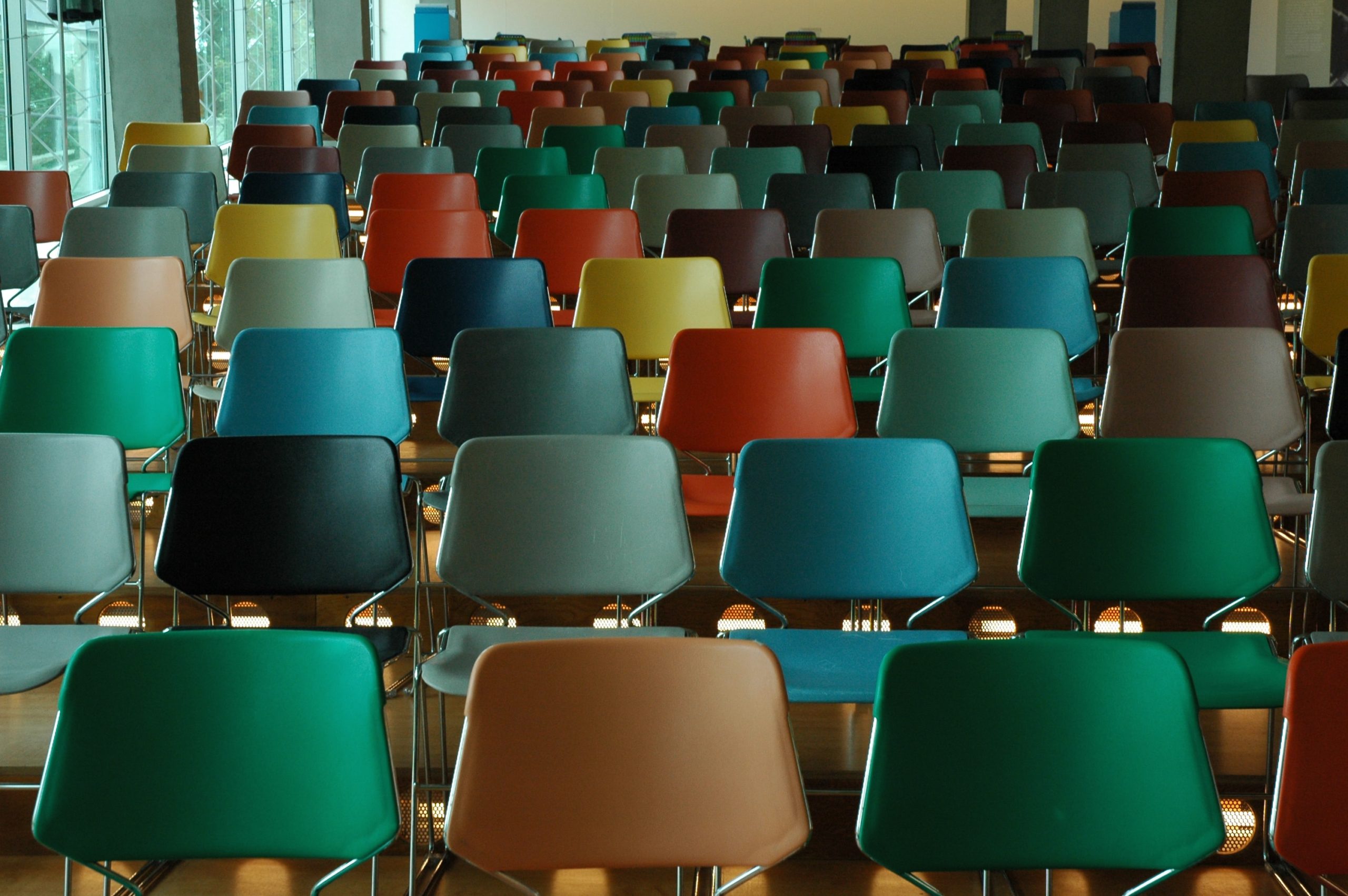 A group of different colored chairs in a classroom.
