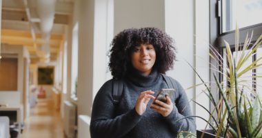Black female college student using smartphone