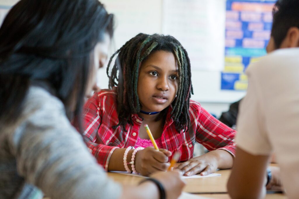 Black female student with dreads in a classroom.