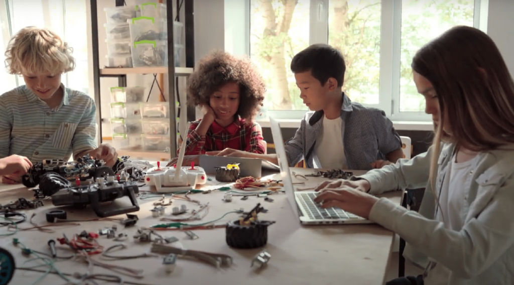 Young students at a table working with robotics.