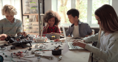 Young students at a table working with robotics.