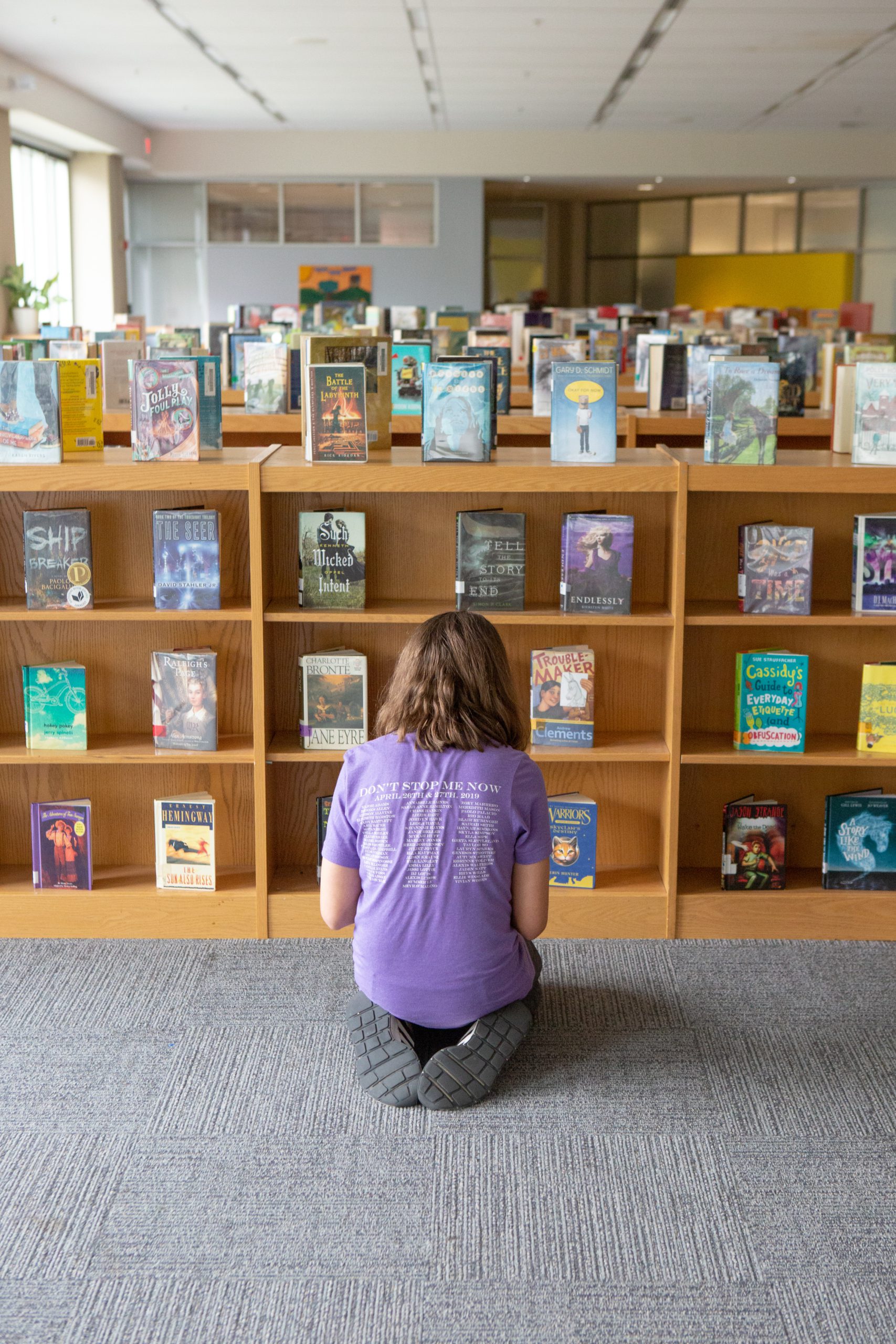 A seventh-grade student looks through books in her school library.