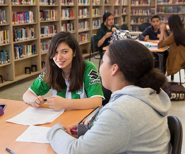 two students talking in a classroom