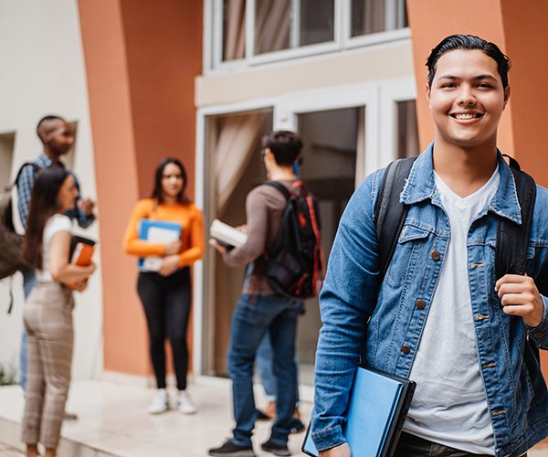 students talking to one another on campus with one male student in the foreground