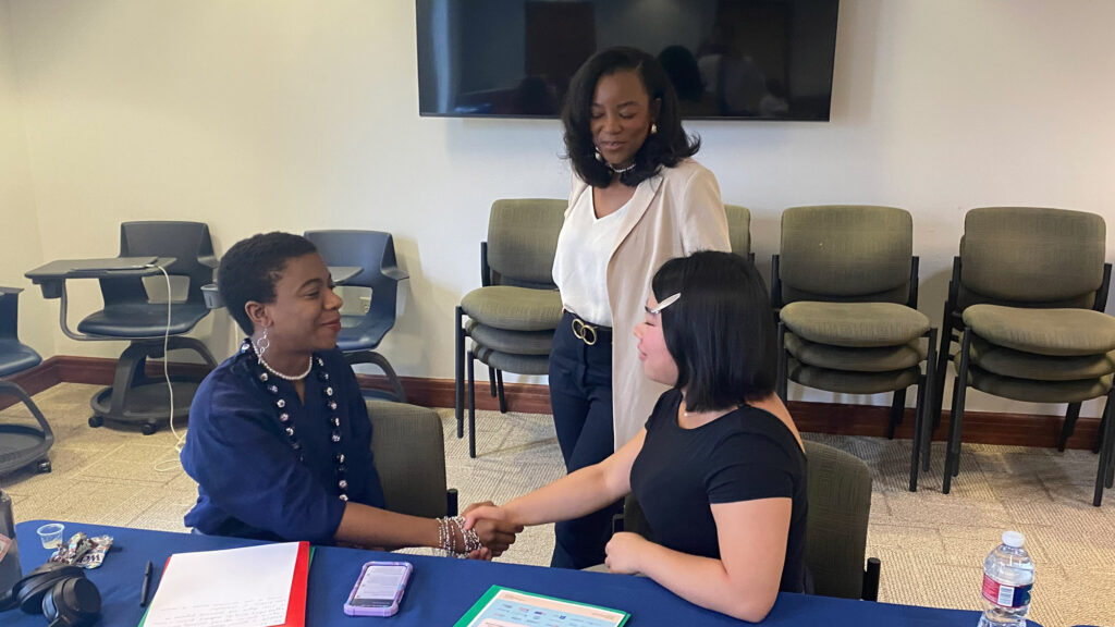 Three education advocates engage in a handshake after hearing from a diverse group of experts at the Student Advocacy in Action Convening.