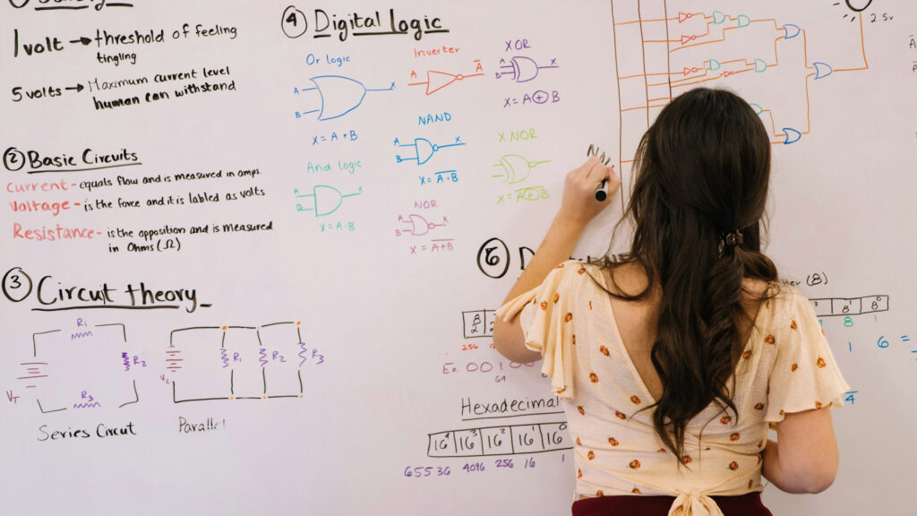 female math student writing mathematical formulas on a white board