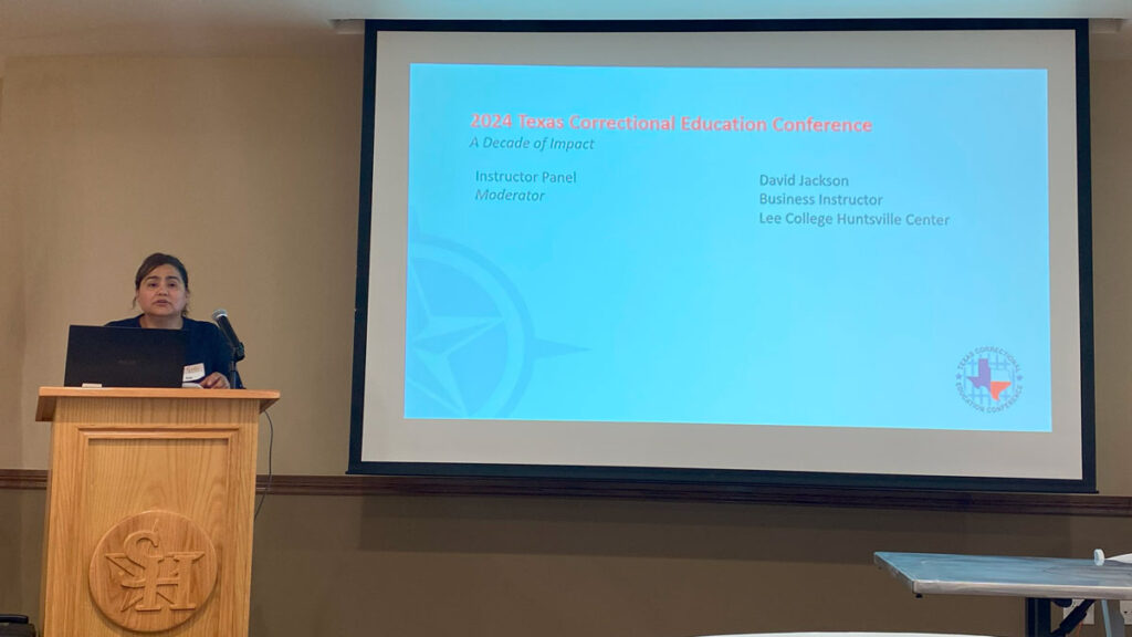 A woman speaking onstage to a microphone on a podium. On the screen to the side is a slide that says 2024 Texas Correctional Education Conference, A Decade of Impact