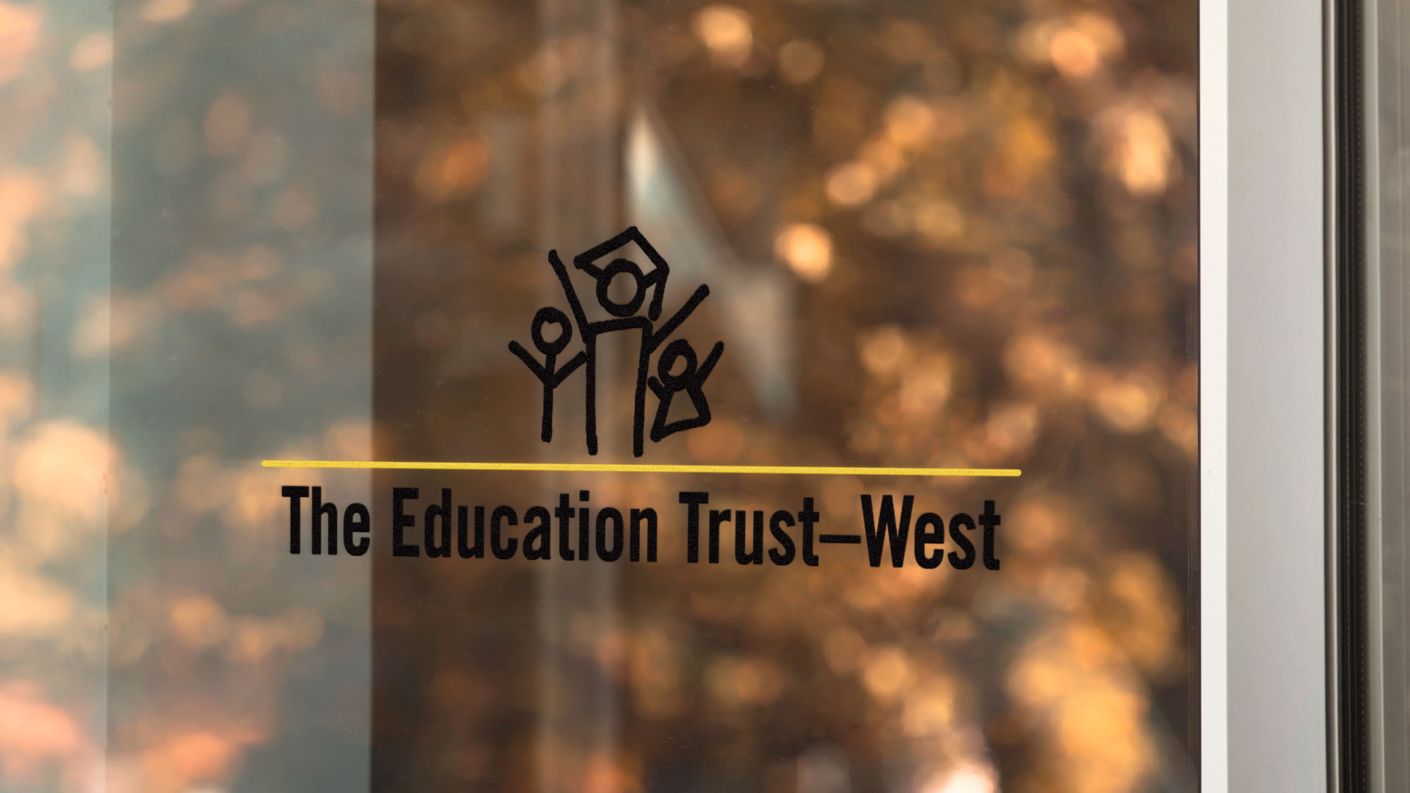 Logo of the Education Trust-West on a clear glass window