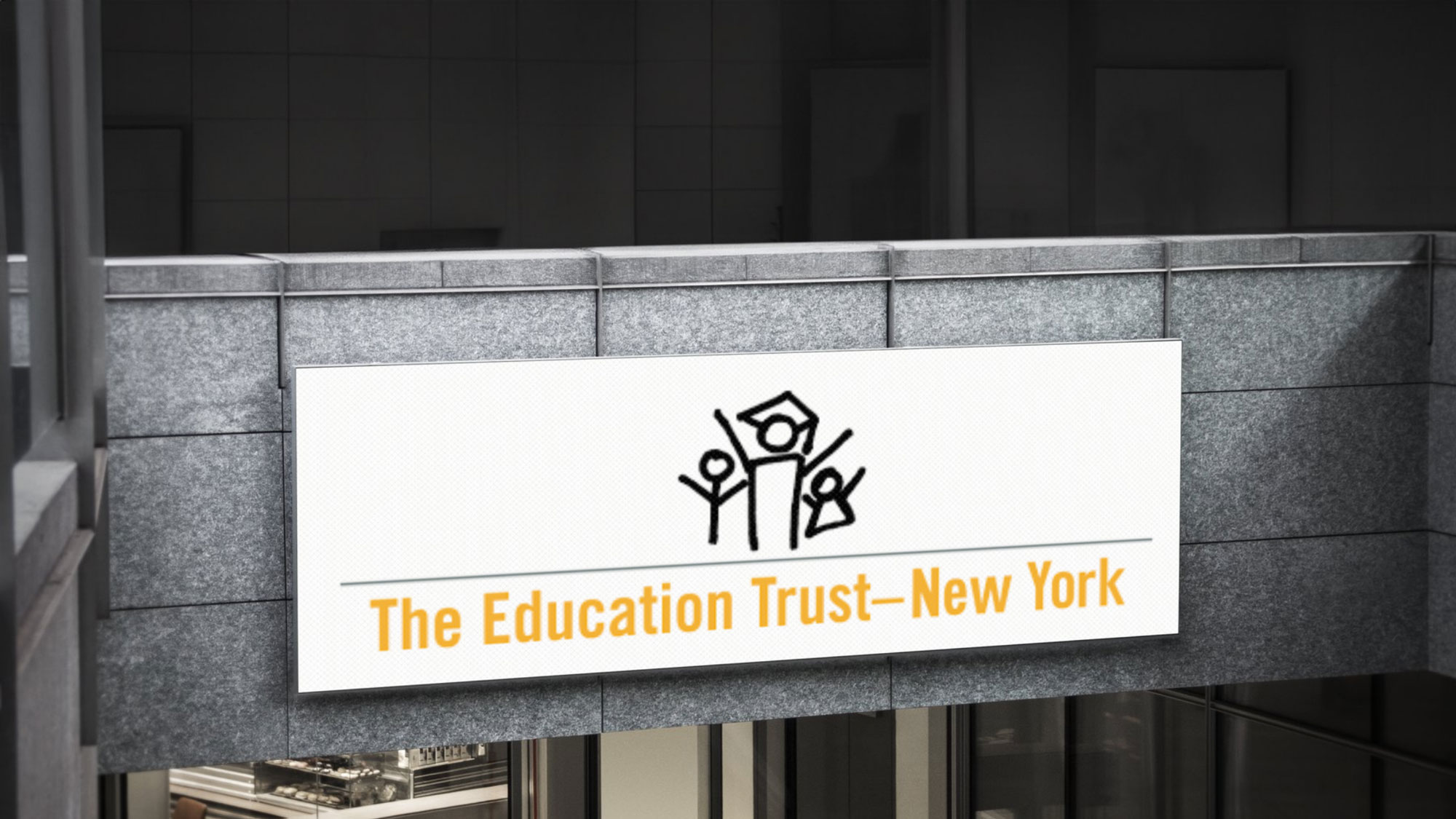 The logo of The Education Trust New-York on an advertising display on a wall
