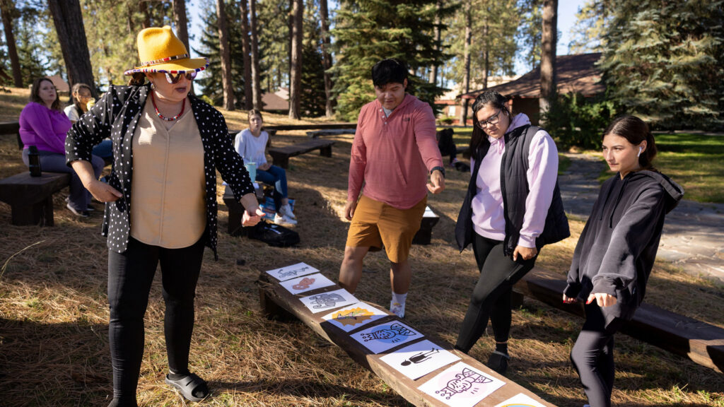 Instructor leading a Native American language class in an outdoor classroom on a college campus