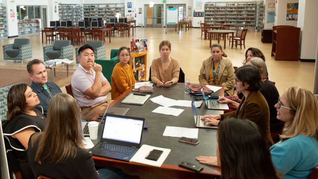 Teachers and staff seated around a table at a faculty meeting