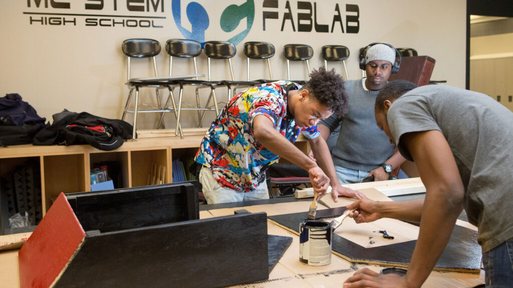 Twelfth-grade engineering students put the finishing touches on a bat house they built in the Fab Lab at MC2 STEM High School