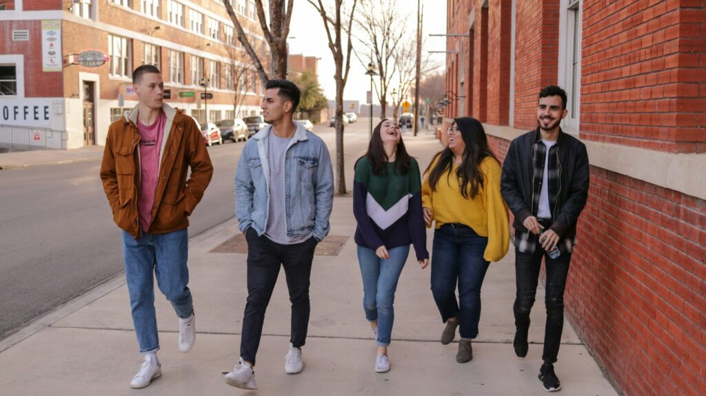 A group of five students walking and laughing