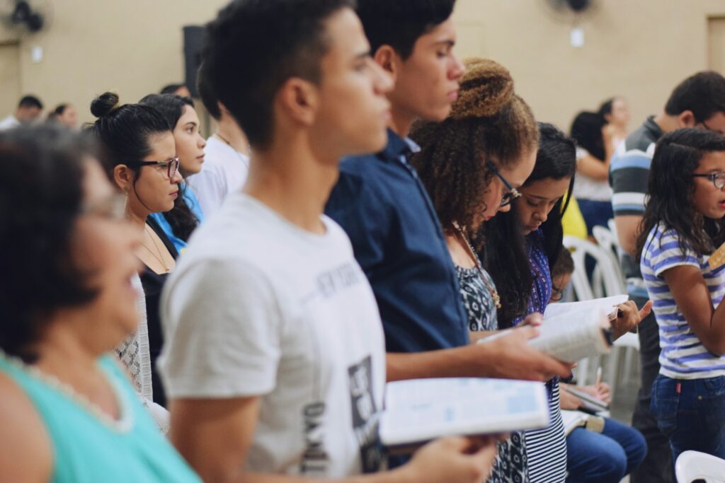 A group of students standing and facing right, holding books
